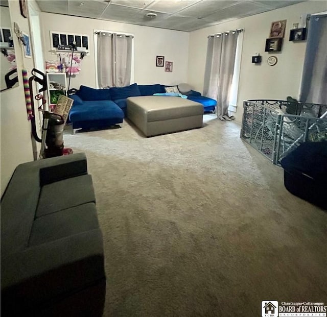 living room with carpet floors and a paneled ceiling