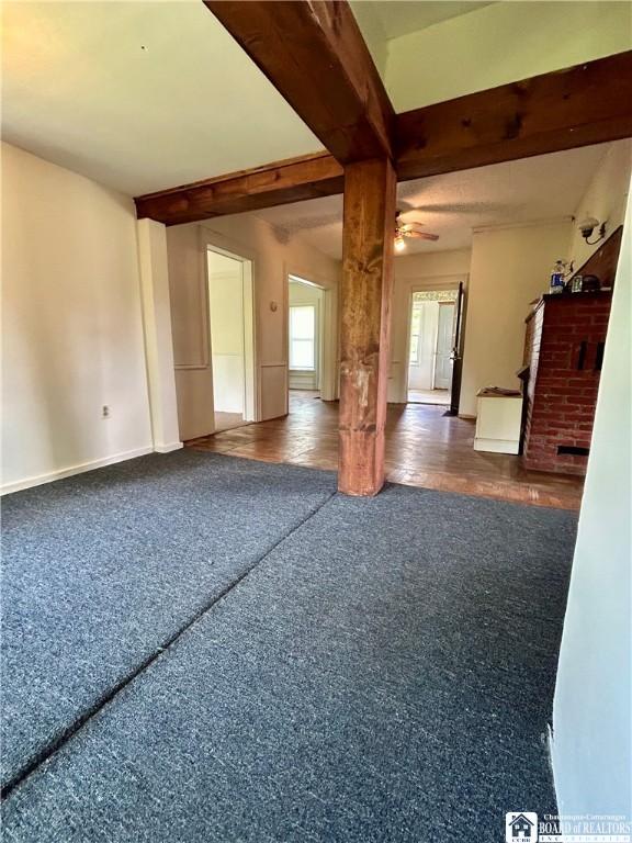 empty room featuring ceiling fan and beam ceiling