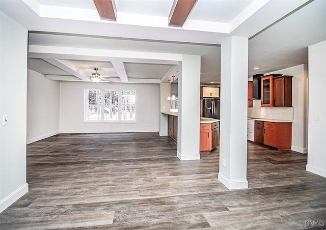 unfurnished living room with coffered ceiling, ceiling fan, beam ceiling, and dark hardwood / wood-style flooring