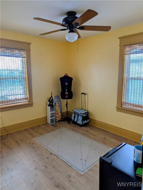 interior space with a wealth of natural light, baseboards, and wood finished floors