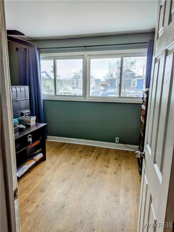 bedroom featuring baseboards and light wood finished floors