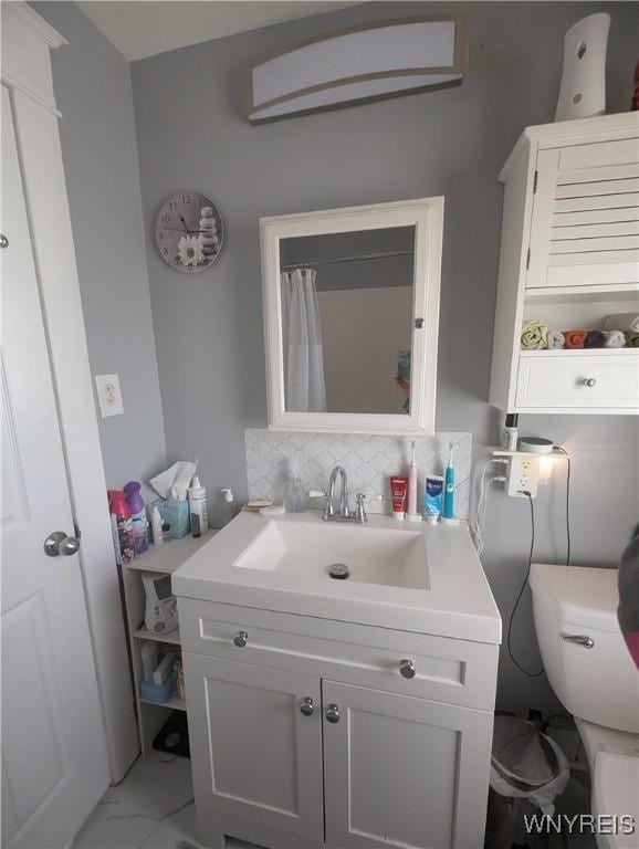 full bathroom featuring backsplash, vanity, marble finish floor, and toilet