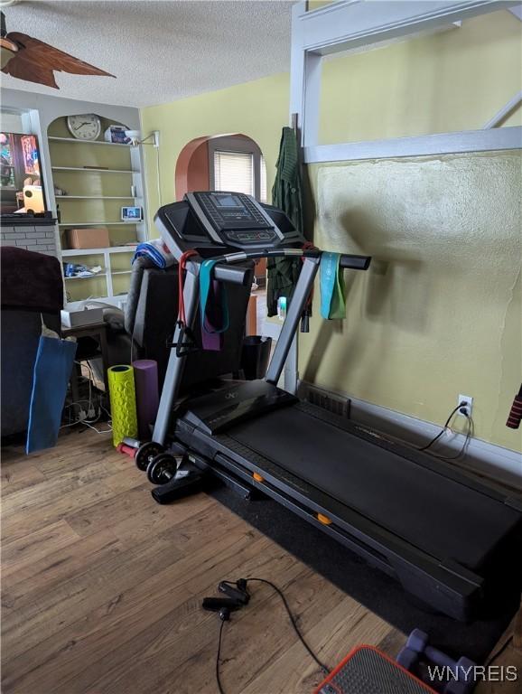 workout room featuring wood finished floors and a textured ceiling