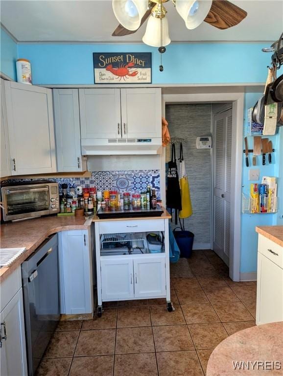 kitchen with ceiling fan, under cabinet range hood, dishwashing machine, tile patterned floors, and white cabinetry