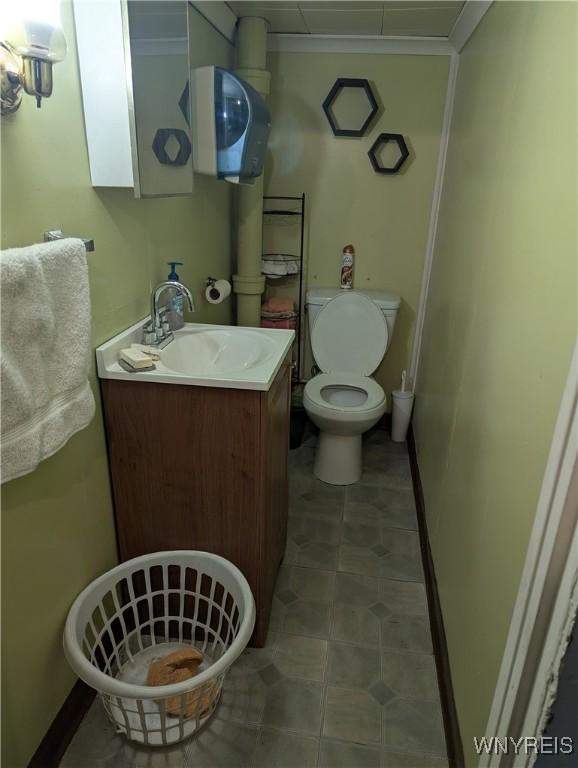 bathroom with toilet, vanity, and baseboards