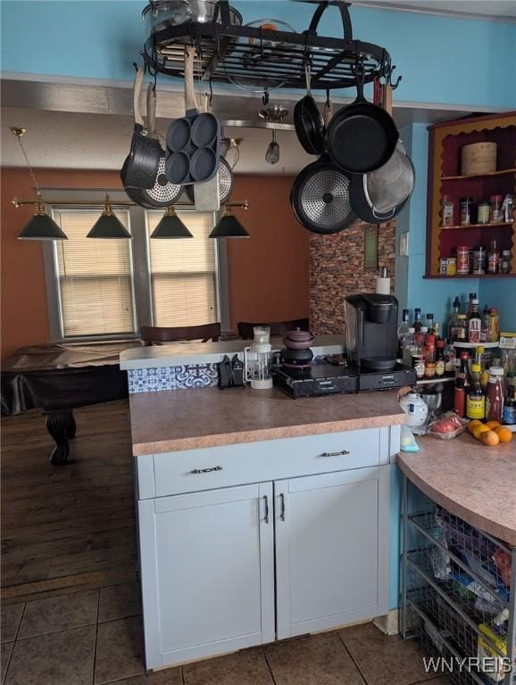 kitchen featuring tile patterned flooring, white cabinets, and cooktop