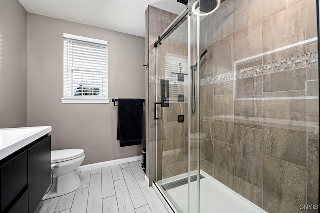 bathroom featuring vanity, toilet, and an enclosed shower