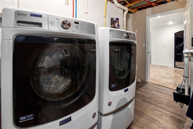 clothes washing area featuring hardwood / wood-style floors and washer and clothes dryer