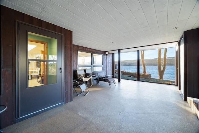 unfurnished sunroom featuring a water view