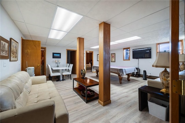 living room with a paneled ceiling and light wood-type flooring