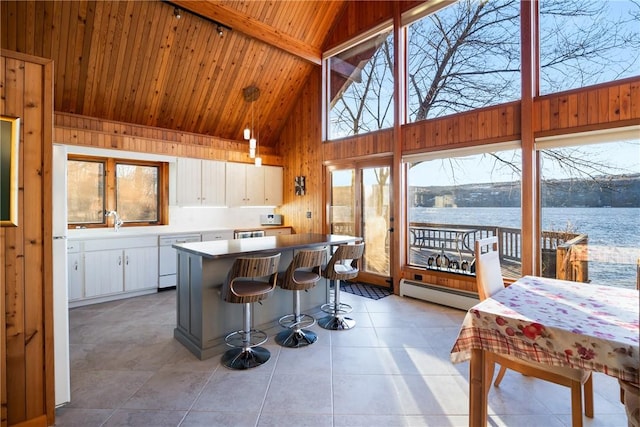 kitchen with high vaulted ceiling, white cabinetry, a baseboard radiator, white dishwasher, and a water view