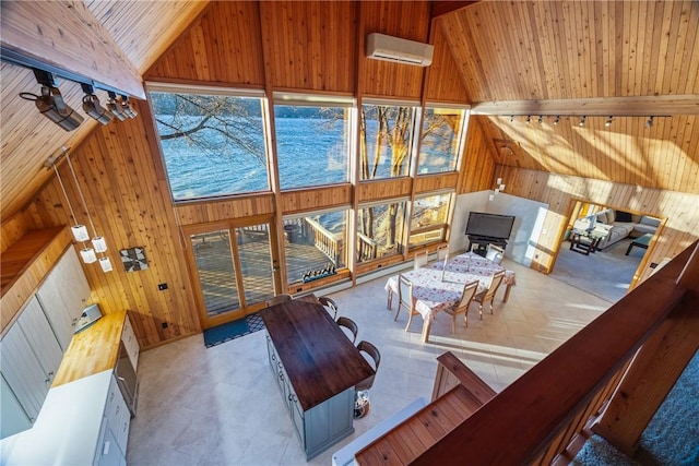 tiled living room featuring wood ceiling, a wall unit AC, high vaulted ceiling, and beamed ceiling