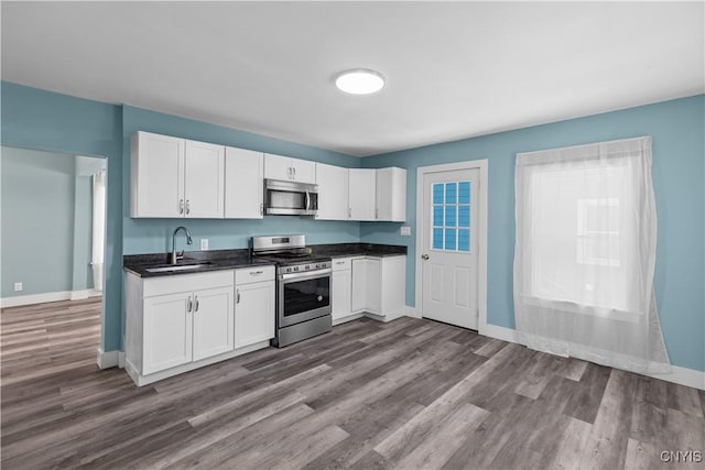 kitchen with white cabinetry, sink, wood-type flooring, and stainless steel appliances