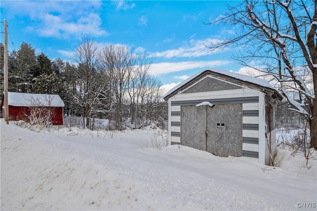 snow covered structure with a garage