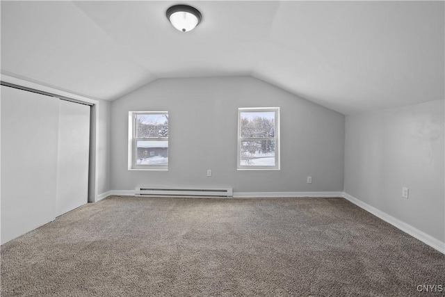 additional living space with baseboard heating, a healthy amount of sunlight, carpet flooring, and vaulted ceiling