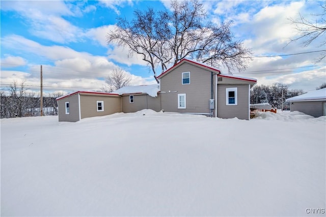 view of snow covered back of property