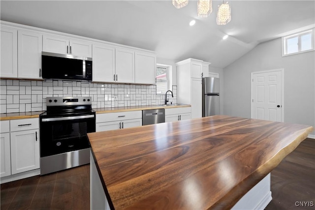 kitchen featuring sink, white cabinetry, stainless steel appliances, wood counters, and decorative light fixtures