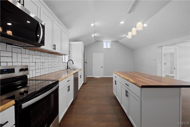 kitchen featuring stainless steel appliances, white cabinetry, vaulted ceiling, and wood counters