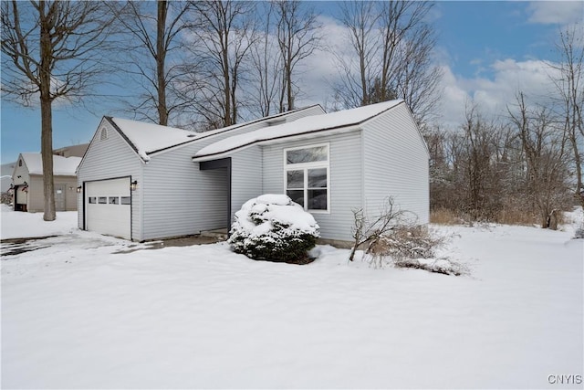 snow covered property featuring a garage