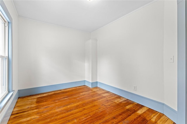 spare room featuring ornamental molding and light wood-type flooring