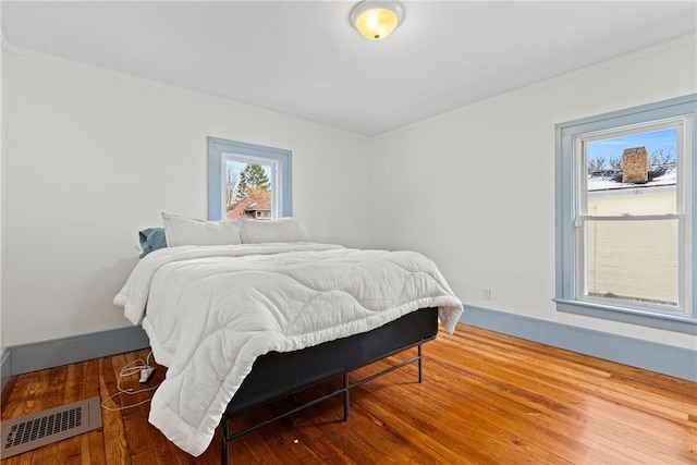 bedroom with crown molding and hardwood / wood-style floors