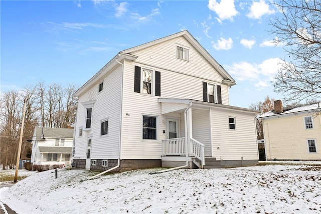 view of snow covered back of property