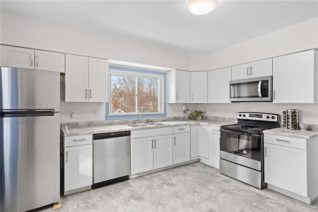 kitchen with white cabinetry, appliances with stainless steel finishes, and sink