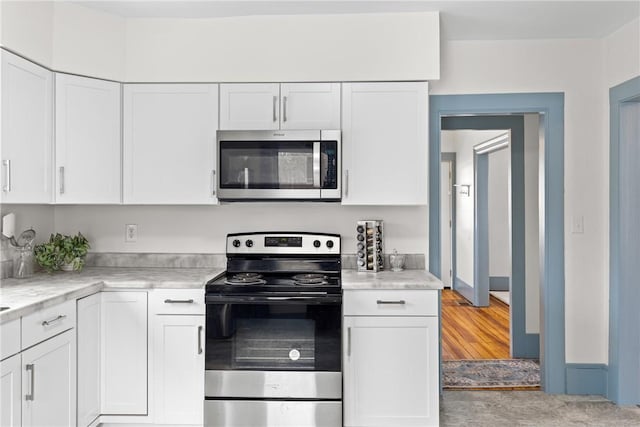 kitchen featuring white cabinetry, light stone counters, and stainless steel appliances