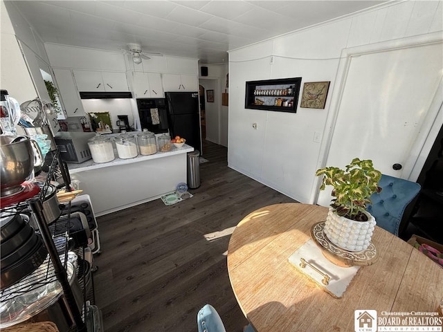 kitchen featuring black refrigerator, ceiling fan, dark wood-type flooring, and white cabinets