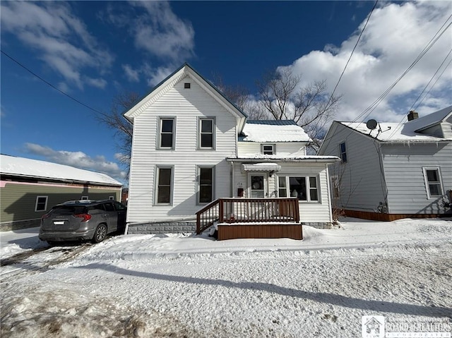 view of snow covered back of property