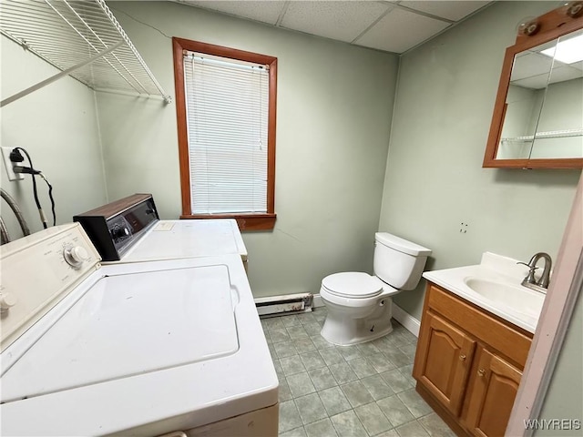 laundry room with sink, washer and clothes dryer, and a baseboard heating unit