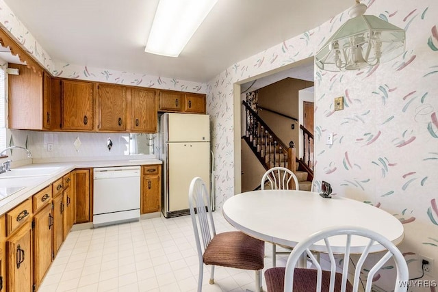 kitchen featuring sink, white appliances, and decorative backsplash