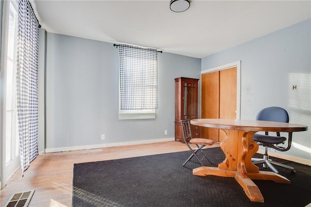 home office with baseboards, light wood-style floors, and visible vents