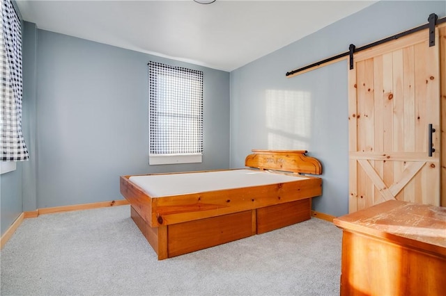 bedroom with a barn door and light carpet