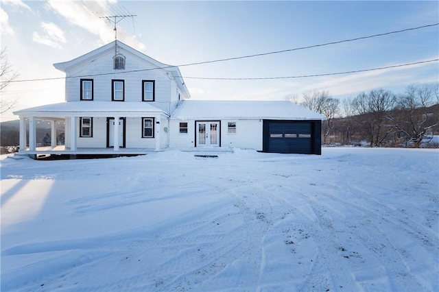 view of front of house with a garage, french doors, and a porch