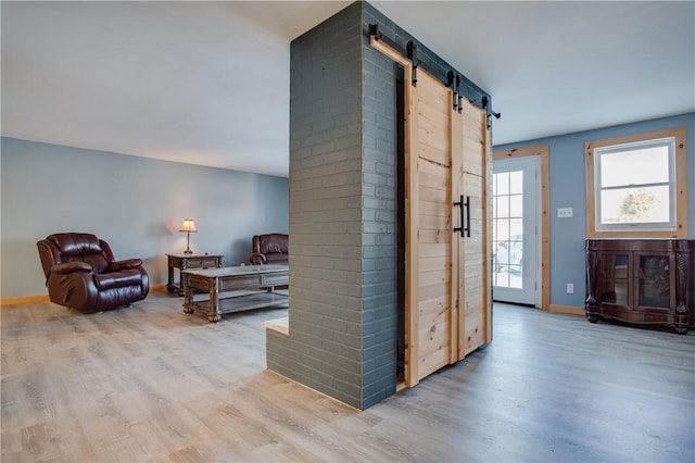 hall featuring a barn door and light wood-type flooring