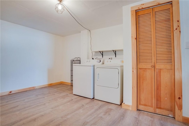 clothes washing area with laundry area, baseboards, separate washer and dryer, and light wood finished floors