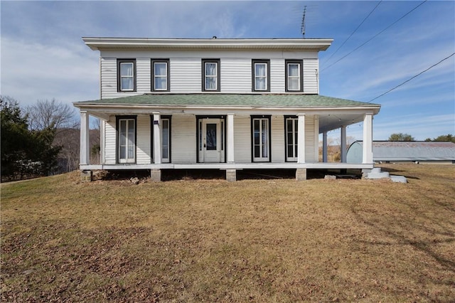 farmhouse featuring a porch, a front yard, and a shingled roof