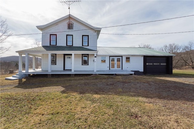 farmhouse-style home featuring dirt driveway, a garage, french doors, and a front yard