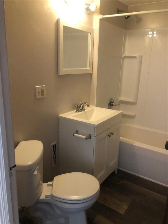 full bathroom with shower / tub combination, wood-type flooring, toilet, and vanity