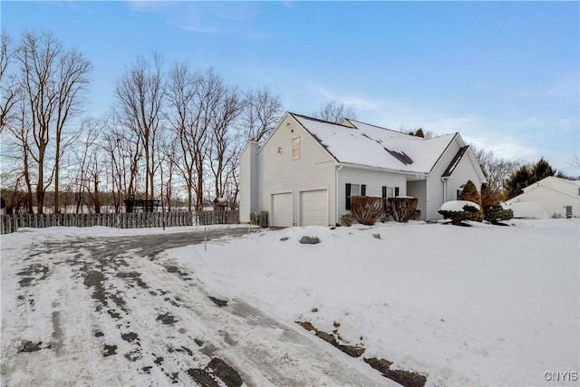 snow covered property with a garage