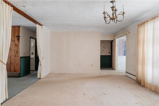 carpeted spare room featuring baseboard heating, a wealth of natural light, and a notable chandelier