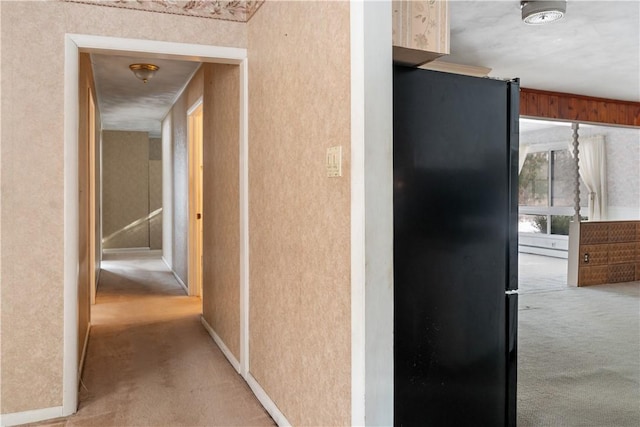 corridor with light colored carpet, ornamental molding, and a baseboard heating unit