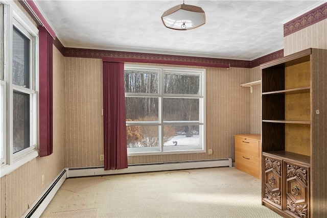 interior space with crown molding, carpet, and a baseboard heating unit