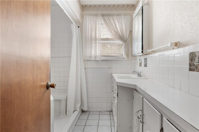 bathroom with tile patterned flooring, vanity, a shower with curtain, and tile walls