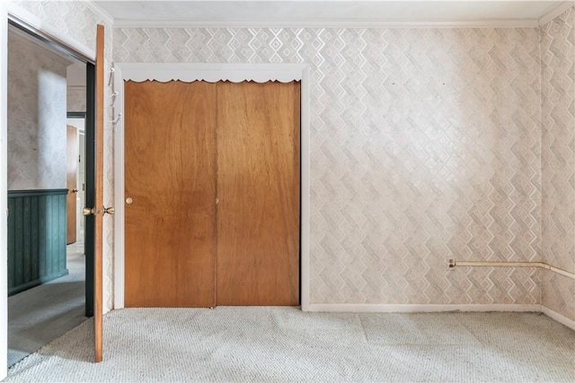 unfurnished bedroom featuring crown molding and a closet