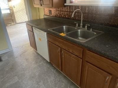 kitchen featuring dishwasher, sink, decorative backsplash, and dark stone counters