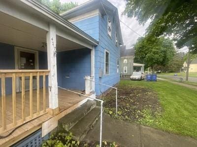 view of property exterior featuring a yard and a porch