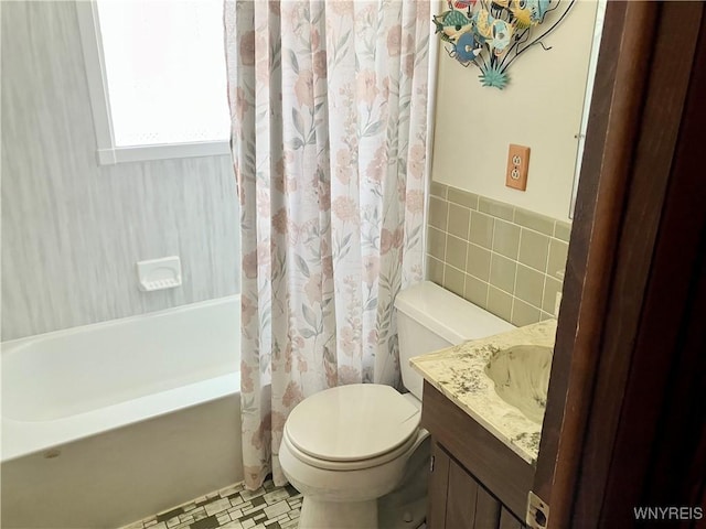 full bathroom with vanity, tile walls, shower / bathtub combination with curtain, and toilet