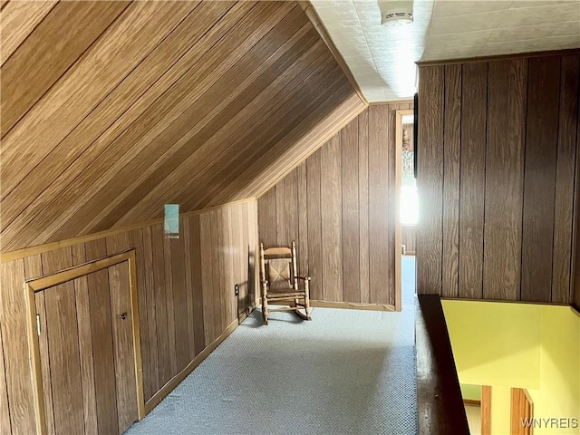 additional living space with light colored carpet, wooden ceiling, and wood walls